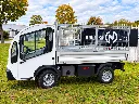 Petit camion-benne blanc chez le concessionnaire.webp